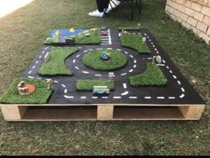 an outdoor play area made out of grass and toys on top of a wooden table