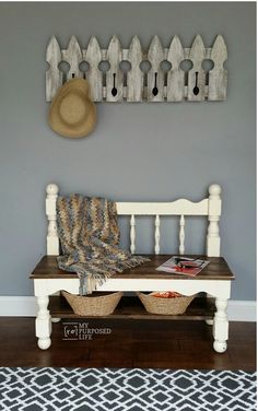 a white bench sitting in front of a wall with a hat on top of it