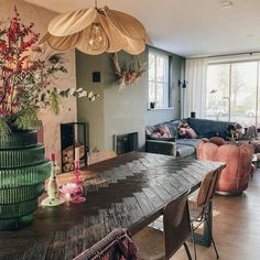 a living room filled with furniture and a wooden table surrounded by flowers on top of it