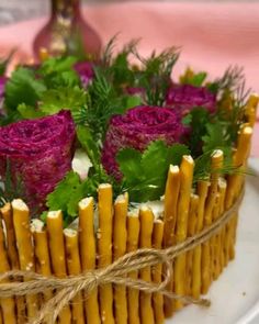 a cake decorated with flowers and greenery on a plate