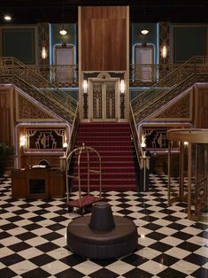 the stairs are decorated with black and white checkered flooring, which has red carpet