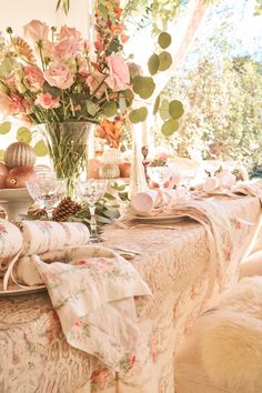 the table is set with flowers and plates