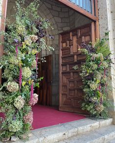 the entrance to an old building with flowers on it