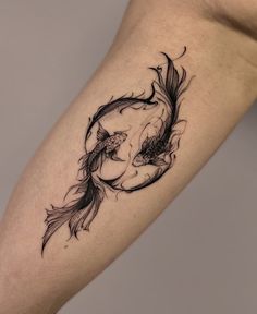 a woman's leg with a tattoo on it that has two fish in the water