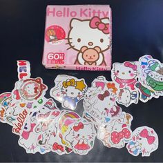 hello kitty stickers are on the table next to a box and some magnets