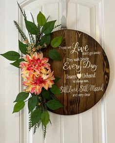 a wooden plaque with flowers on the front door