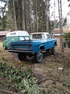 two trucks parked in the woods next to each other