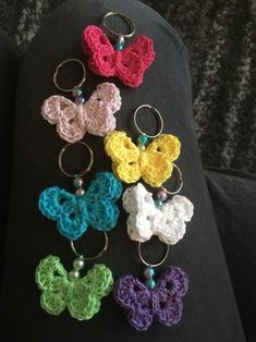 six crocheted butterfly keychains on a black cloth