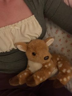 a woman holding a stuffed deer in her arms and wearing a diaper on top of her stomach