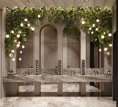 a bathroom with marble counter tops and plants growing on the wall above it, along with two sinks