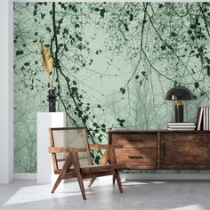 a room with green wallpaper and a wooden dresser in front of it, next to a lamp on a table