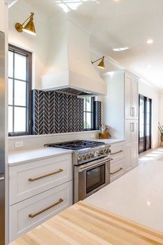 a kitchen with white cabinets and stainless steel appliances, along with an island countertop