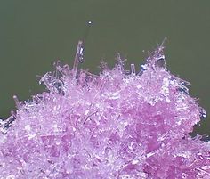 a close up view of some purple glass with needles sticking out of it's center