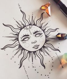 a drawing of a sun with eyes and stars on the surface next to some crystals