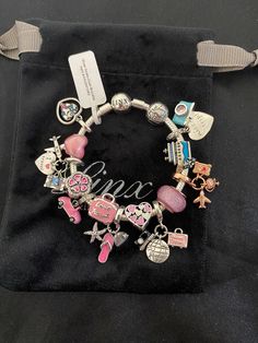 the charm bracelet is on display in a black velvet bag with a name tag attached to it