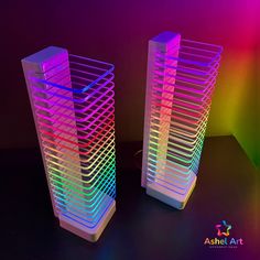 two tall plastic racks with different colored lights on top of each one in front of a black background