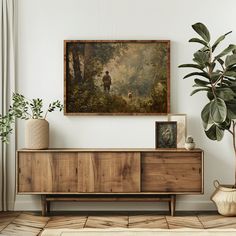 a painting hanging on the wall next to a dresser and potted plant in front of it