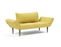 a yellow couch sitting on top of a white floor next to a wooden leg chair