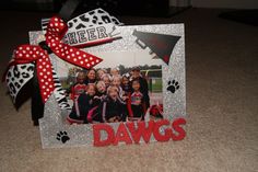 a picture frame that has some pictures on it with a red ribbon around the edges