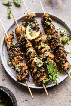 grilled chicken skewers with herbs and lemon on a plate