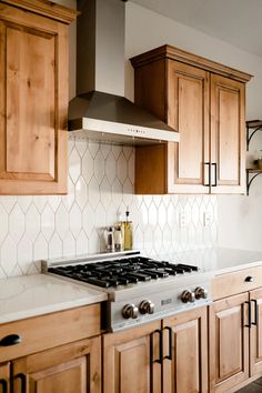 a stove top oven sitting inside of a kitchen next to wooden cupboards and cabinets