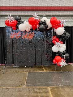 the balloon arch is decorated with red, white and black balloons