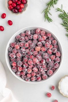 a white bowl filled with cranberries next to some sugar and sprinkles