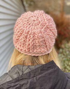 the back of a woman's head wearing a pink knitted hat