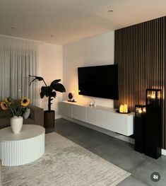 a modern living room with white furniture and sunflowers in vases on the table