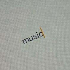 the word music is placed on top of a white surface with an orange and black stripe