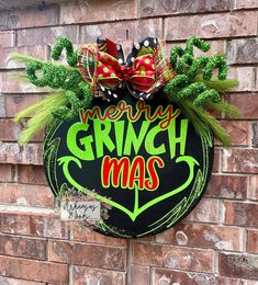 a sign that says merry grinchmas hanging on a brick wall