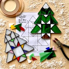 the paper is cut out to make a christmas tree ornament with scissors and glue