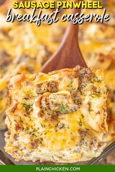 a wooden spoon is holding up a cheesy casserole with meat and cheese