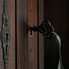 an old door handle is attached to the wooden door with a white ribbon hanging from it