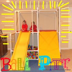 two children are playing on a slide in the playroom with balls and plastic toys