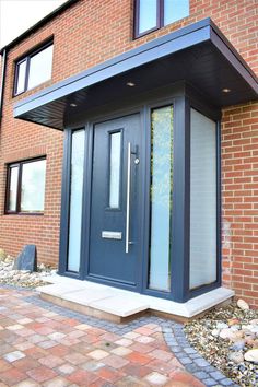 a blue front door on the side of a brick building