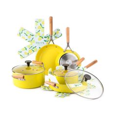 yellow pots and pans with wooden spoons on white background, including spatula