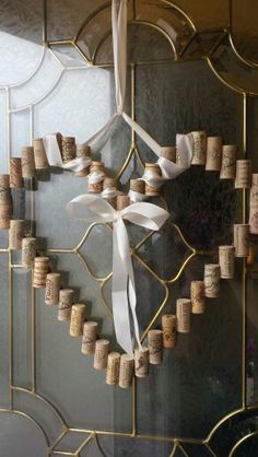 a cross made out of wine corks hanging on a wall