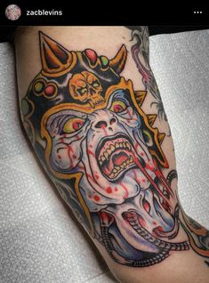 a man's leg with a tattoo on it and an image of a demon