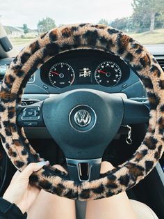 a woman is sitting in the driver's seat of a car with her hands on the steering wheel