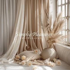 a vase with flowers sitting on top of a bed next to a window covered in drapes