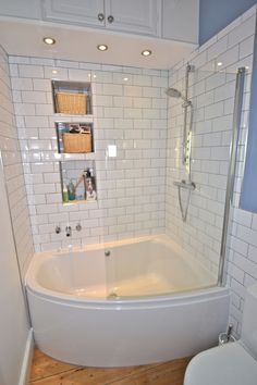 a white bath tub sitting next to a toilet