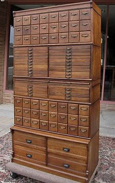 an old wooden filing cabinet with many drawers