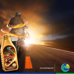 a man riding on the back of a motorcycle next to a bottle of motor oil