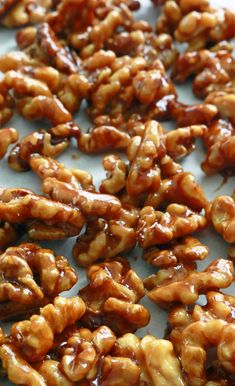 some nuts that are sitting on a white surface and one is covered in caramel