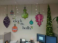 an office cubicle decorated for christmas with ornaments hanging from the ceiling and decorations on the wall