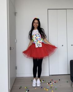 a woman in a red tutu skirt and white shirt standing next to a door