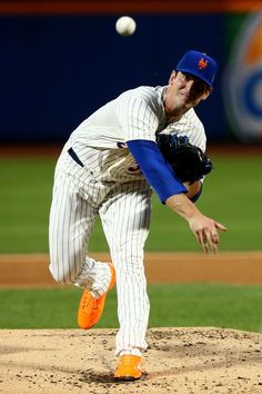 a baseball player pitching a ball on top of a field