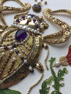 an elaborately designed brooch and earring on a piece of cloth with beads