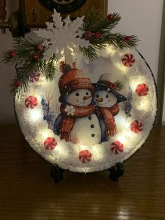 a lighted snow globe with two snowmen on it